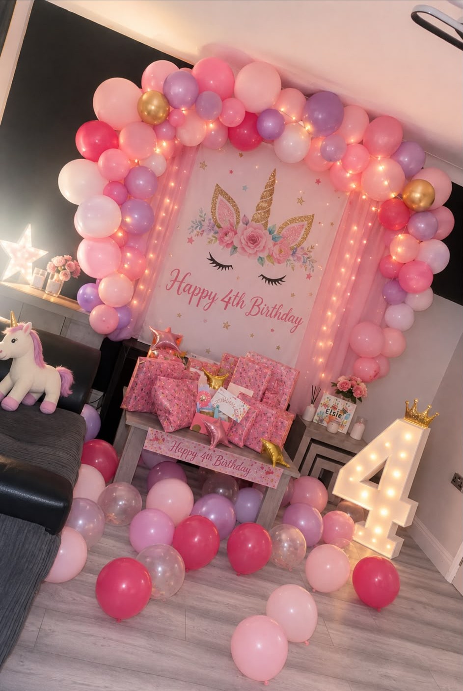 Birthday setup with red and white balloon towers and illuminated number display